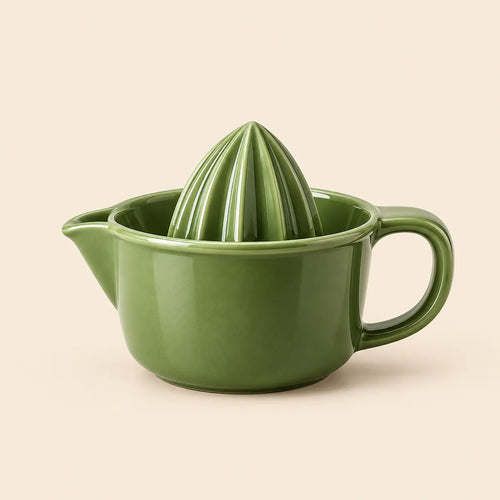 Verdelique olive green manual citrus juicer on a warm ivory background