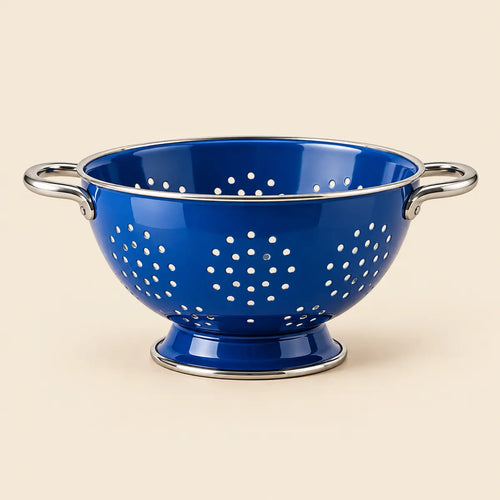 Cobalt-blue footed kitchen colander on a warm ivory background