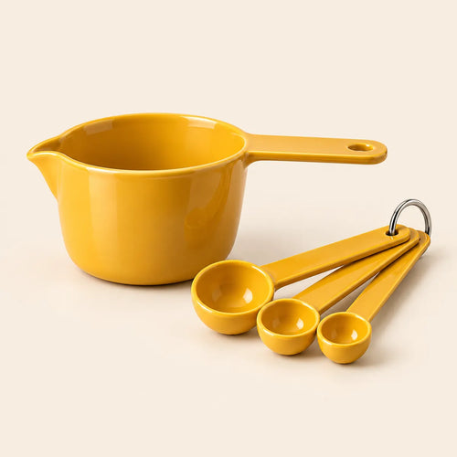 Verdelique mustard-yellow measuring cup and spoon set on a warm ivory background